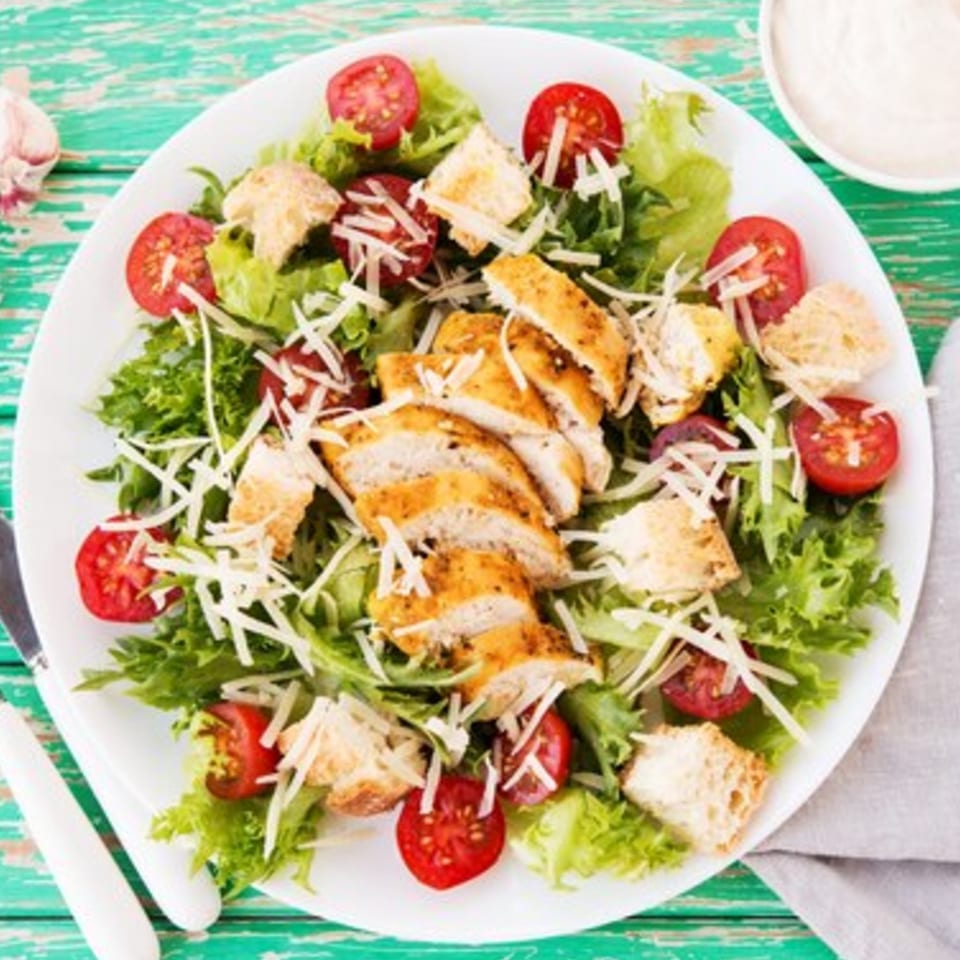 Soho Pizza & Grill's chicken Caesar salad with lettuce, tomatoes, croutons, and shredded cheese.